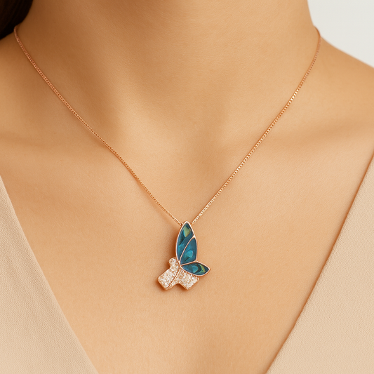 Butterfly-shaped necklace with gemstones on a person wearing a beige top