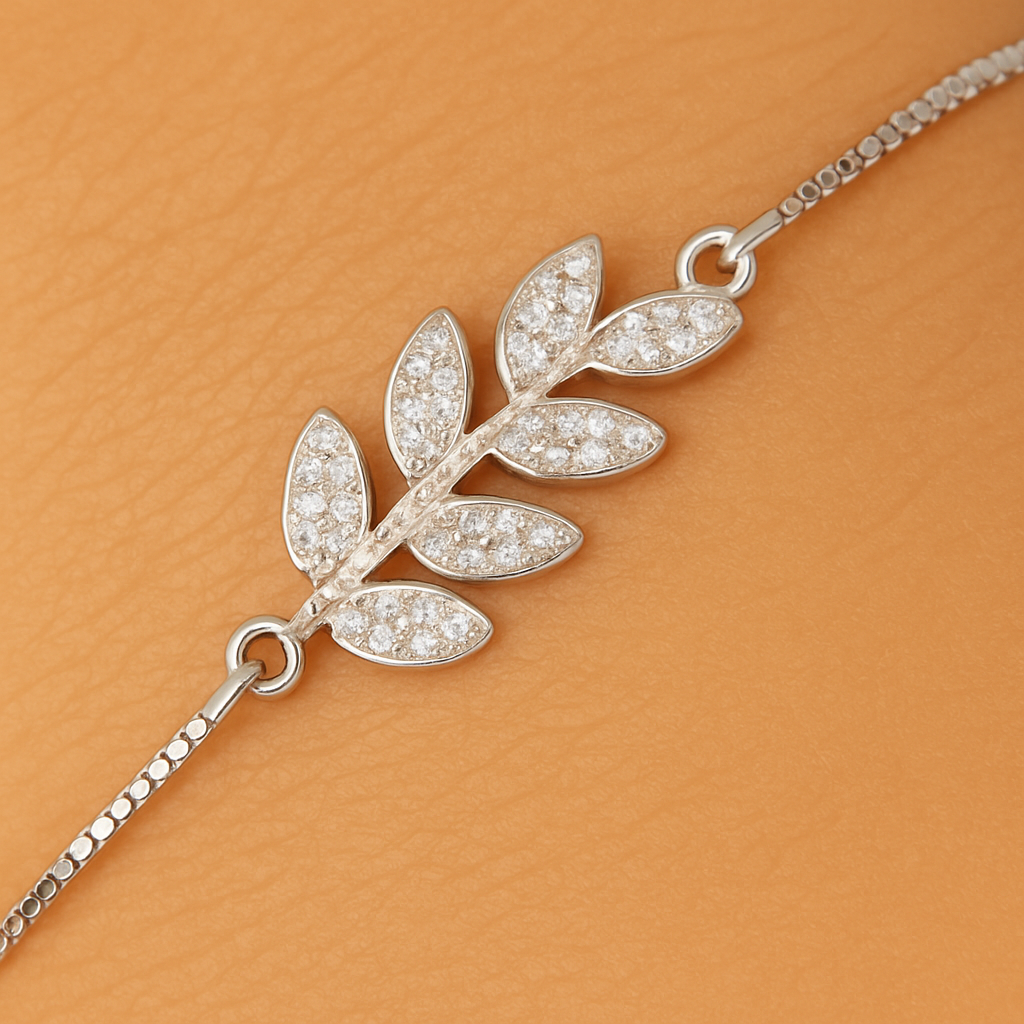 Silver leaf-shaped pendant on a chain against an orange background