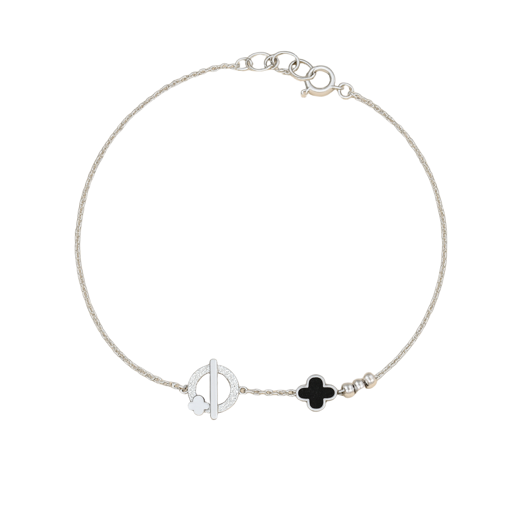 Silver bracelet with black clover charm on a beige background