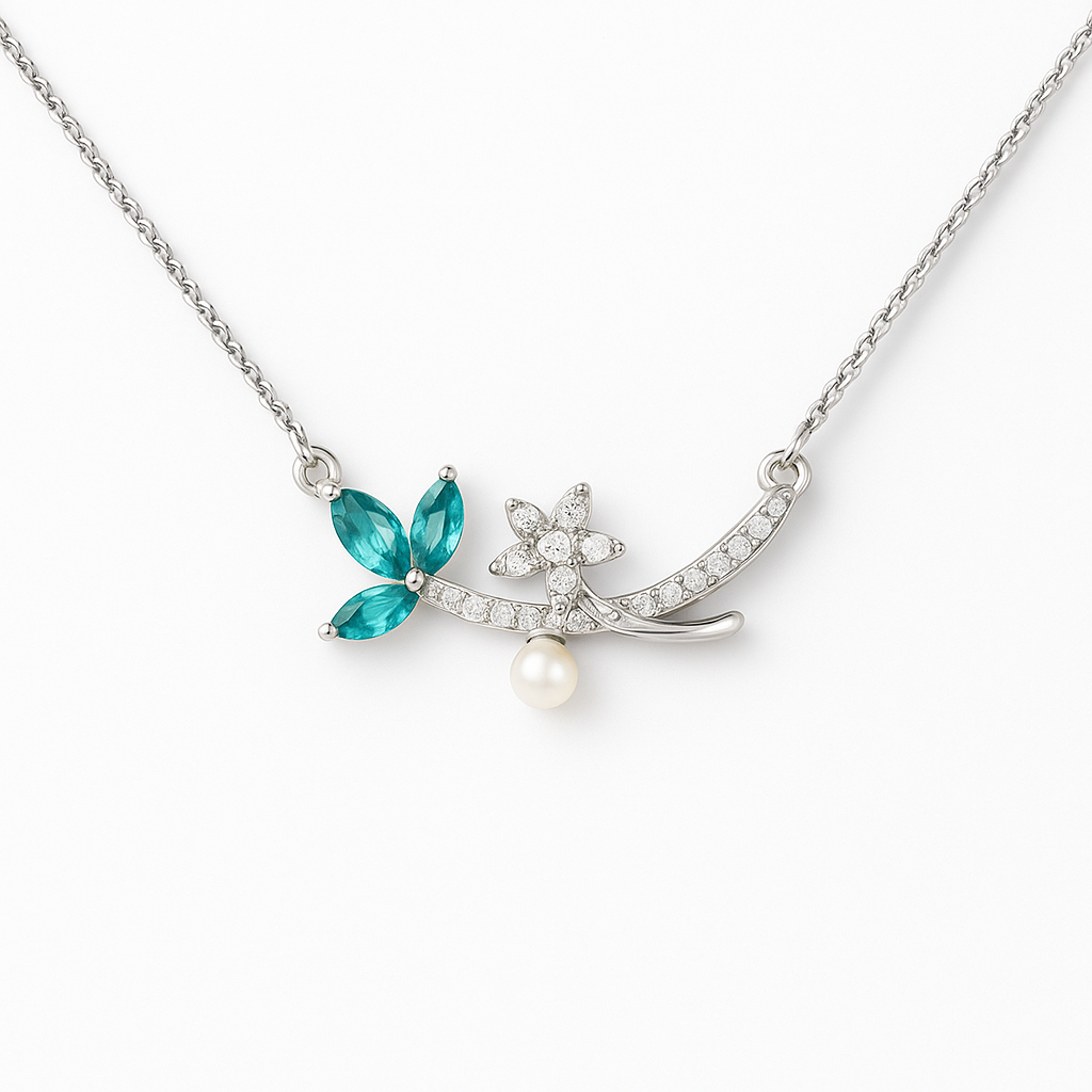 Delicate necklace with a blue gemstone, pearl, and silver chain on a white background