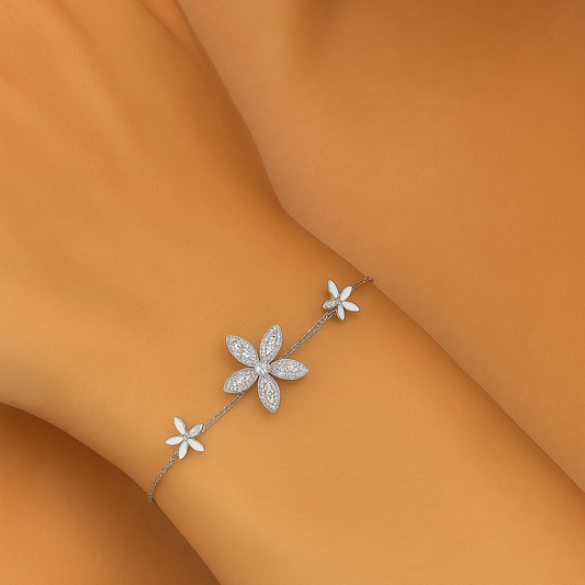 Silver floral bracelet on a person's wrist against an orange background