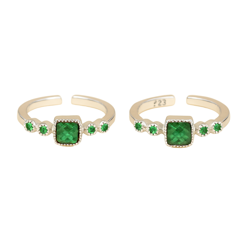 Two silver rings with green gemstones on a white background