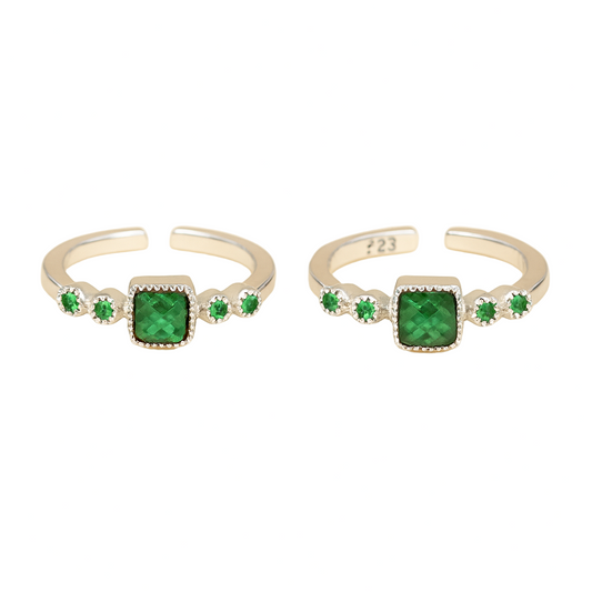 Two silver rings with green gemstones on a white background