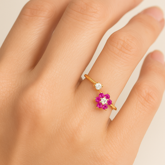 Gold ring with pink gemstones on a hand against a neutral background