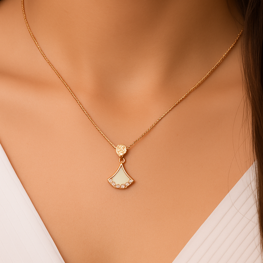 Gold necklace with a pendant on a model wearing a white top