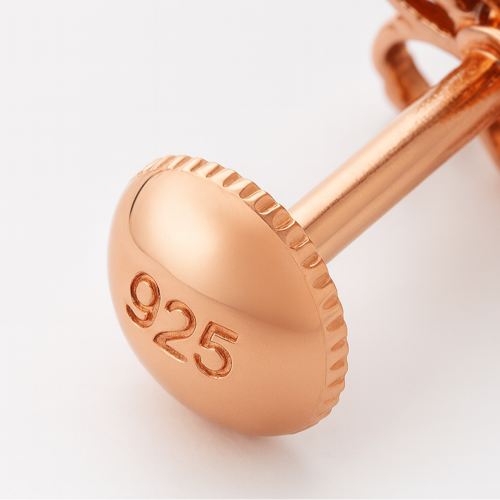 Rose gold earring with '925' stamp on a light background