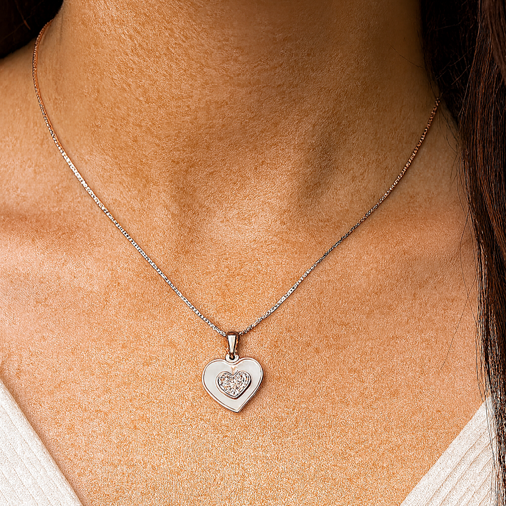 Close-up of a person wearing a silver heart-shaped pendant necklace.