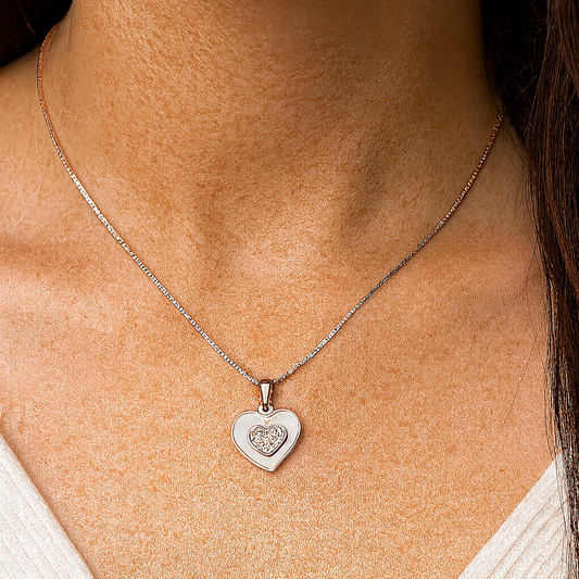 Close-up of a person wearing a silver heart-shaped pendant necklace.