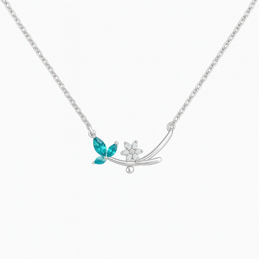 Silver necklace with blue gemstone leaves and white gemstone flower on a white background
