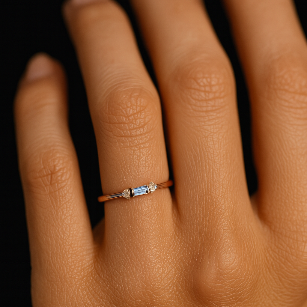 Close-up of a hand wearing a ring with gemstones on a dark background