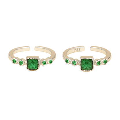 Two silver rings with green gemstones on a white background