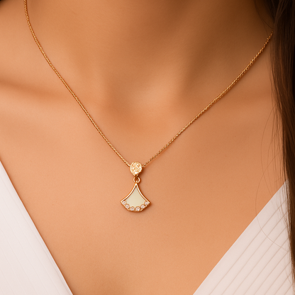 Gold necklace with a pendant on a model wearing a white top