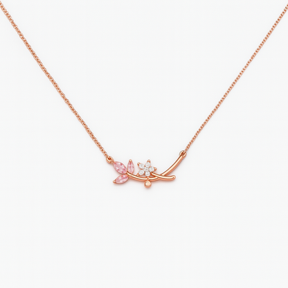 Rose gold necklace with floral pendant on a white background